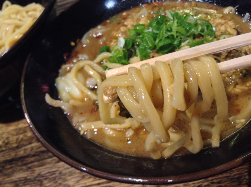 酸味のきいたチャーシューまみれの濃厚タレに、瑞々しく武骨な麺を絡めて